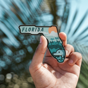 a hand holding a florida magnet