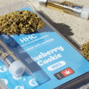 blue HHC cart next to a cannabis flower bud