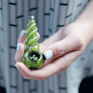 ground cannabis flower in a green pipe