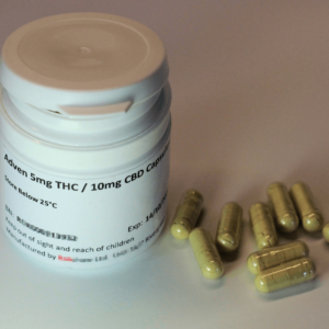 cannabis capsules next to white prescription bottle