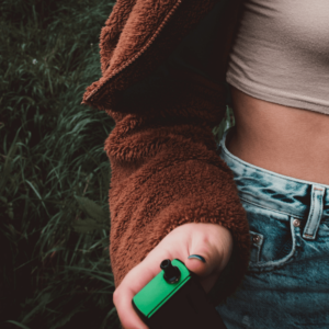 girl holding a black and green vape