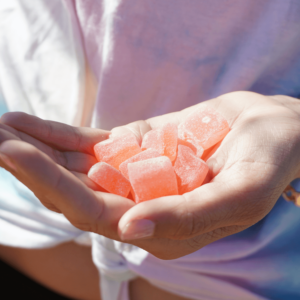 a hand holding pink CBD gummies