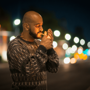 man in sweater smoking a joint