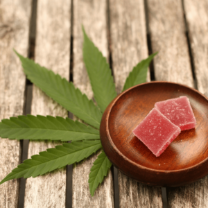 red cannabis gummies on a wooden bowl