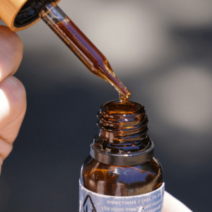 person holding amber tincture bottle