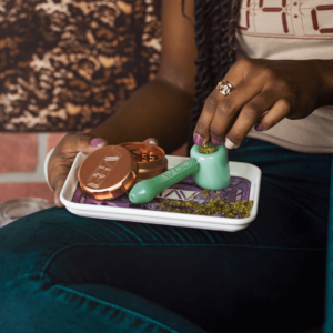 girl packing a bowl with ground flower