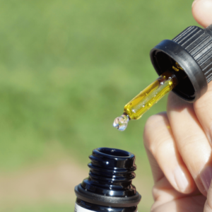 hand holding gold cannabis oil