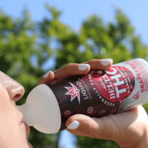 person drinking THC drink with red label