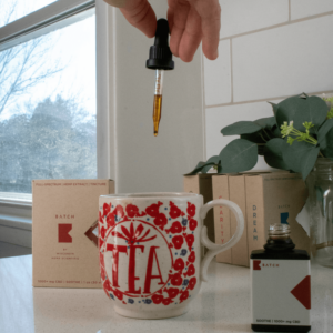 person adding amber liquid to mug