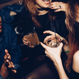 people holding drinks at a bar