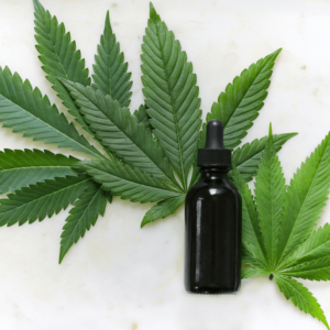 tincture bottle on top of cannabis leaves