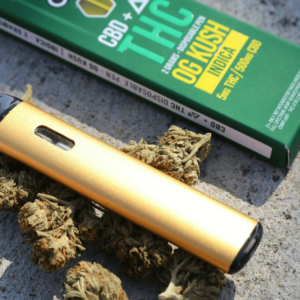 a gold lighter next to a box of marijuana