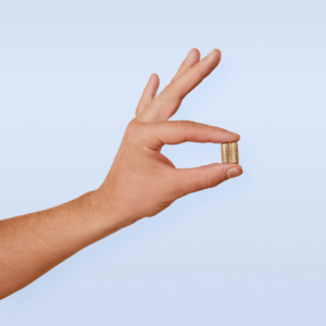 hand holding two herbal capsules