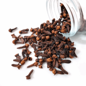 jar of cloves spilling out against white background