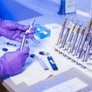 person in lab gear assembling vape cart