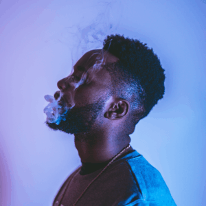 man in purple room smoking vape 