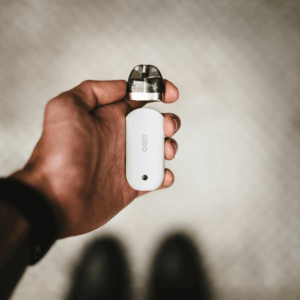 hand holding white vape with pod