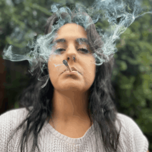 girl blowing smoke from joint
