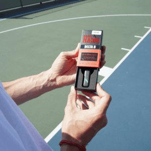 person holding delta 8 vape and packaging