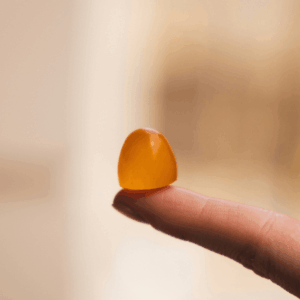 orange gummy on fingertip