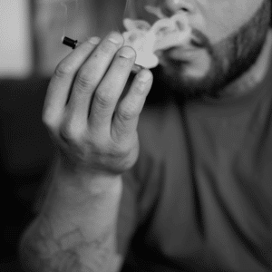 greyscale image of man smoking