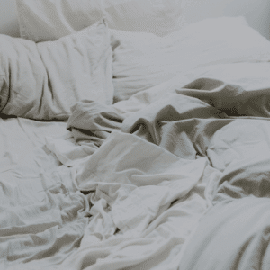 unmade bed with white sheets