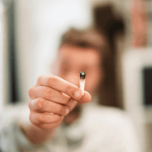 person holding up burnt joint
