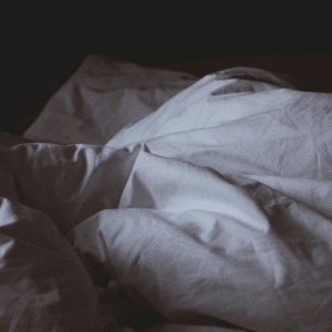 unmade bed dark sheets
