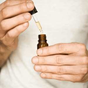 person in white shirt holding oil bottle