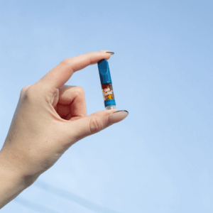 hand holding a vape cart up to the sky