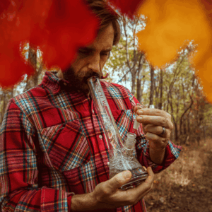 man in flannel shirt smoking from bong