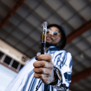 man holding up vape pen to camera