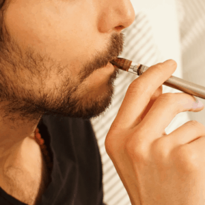 man with beard smoking weed pen